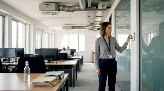 Manager checks air conditioning control panel in office
