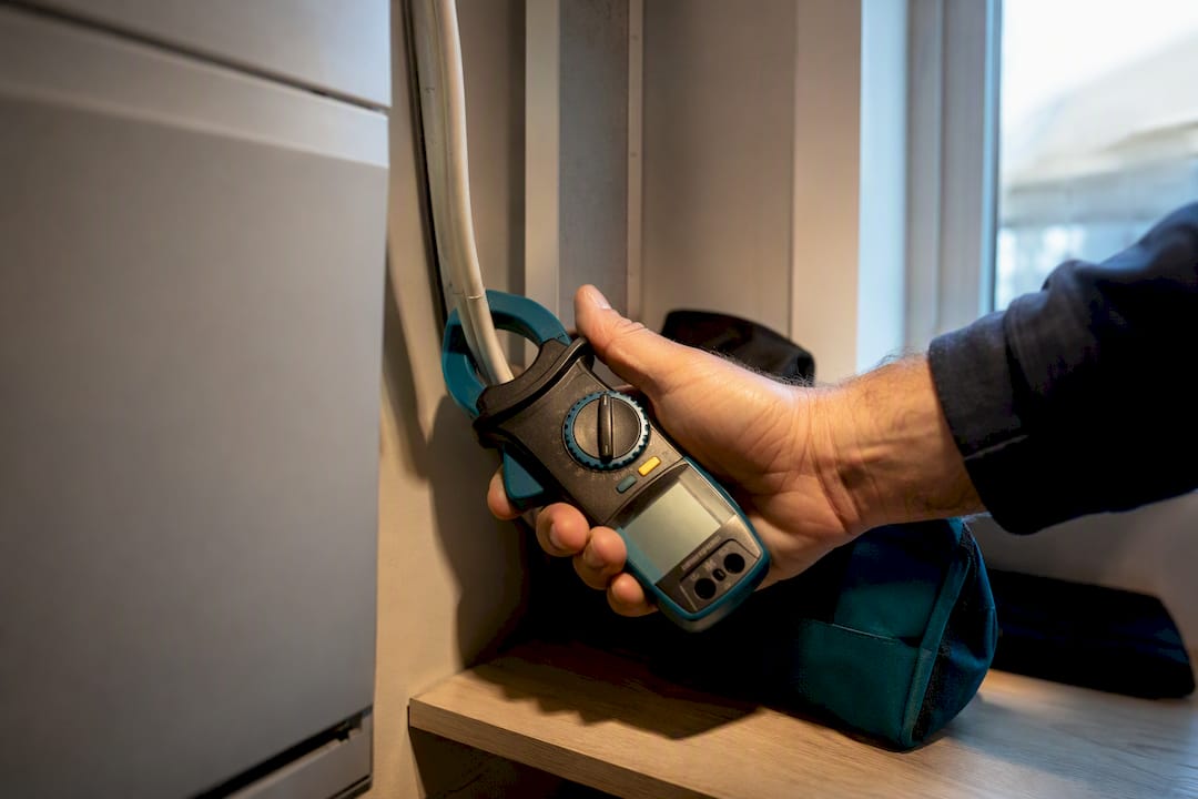 Technician measuring air conditioner power draw