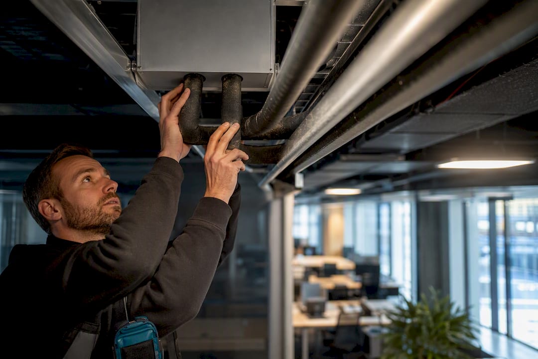 Technician inspecting VRF refrigerant pipework
