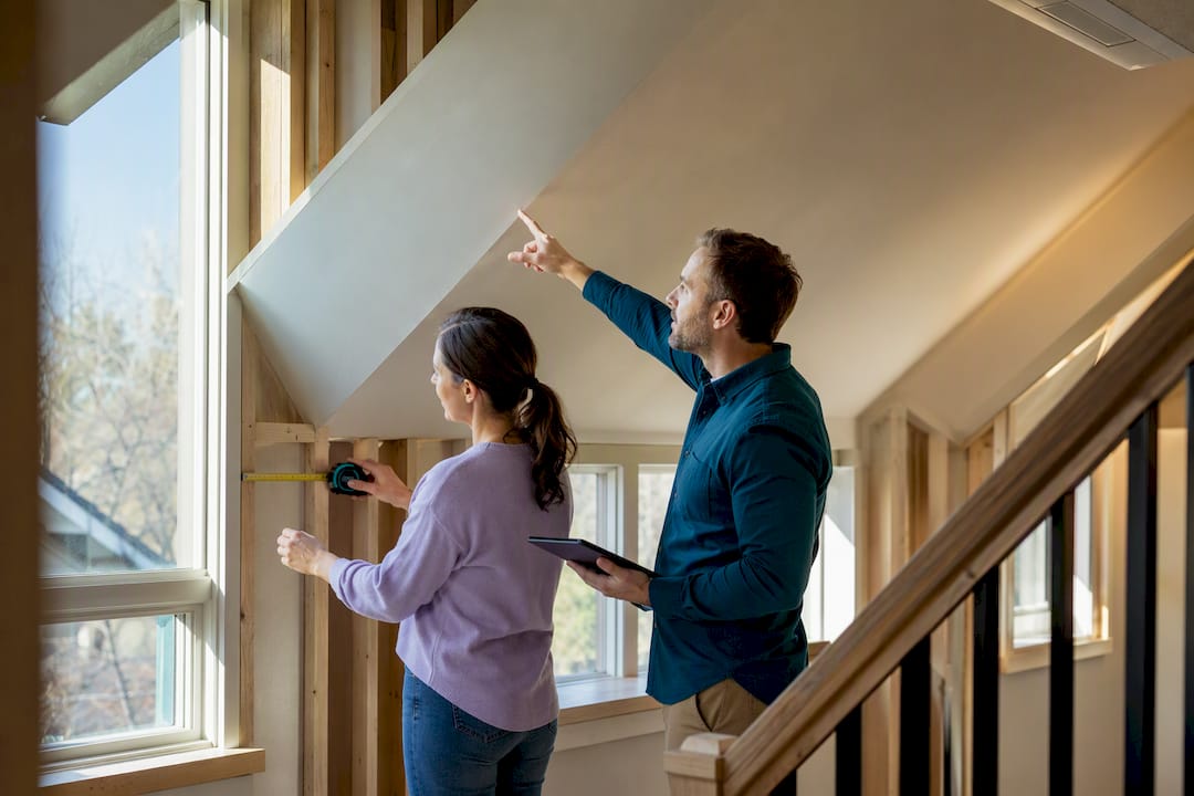 Homeowner and contractor reviewing loft HVAC layout
