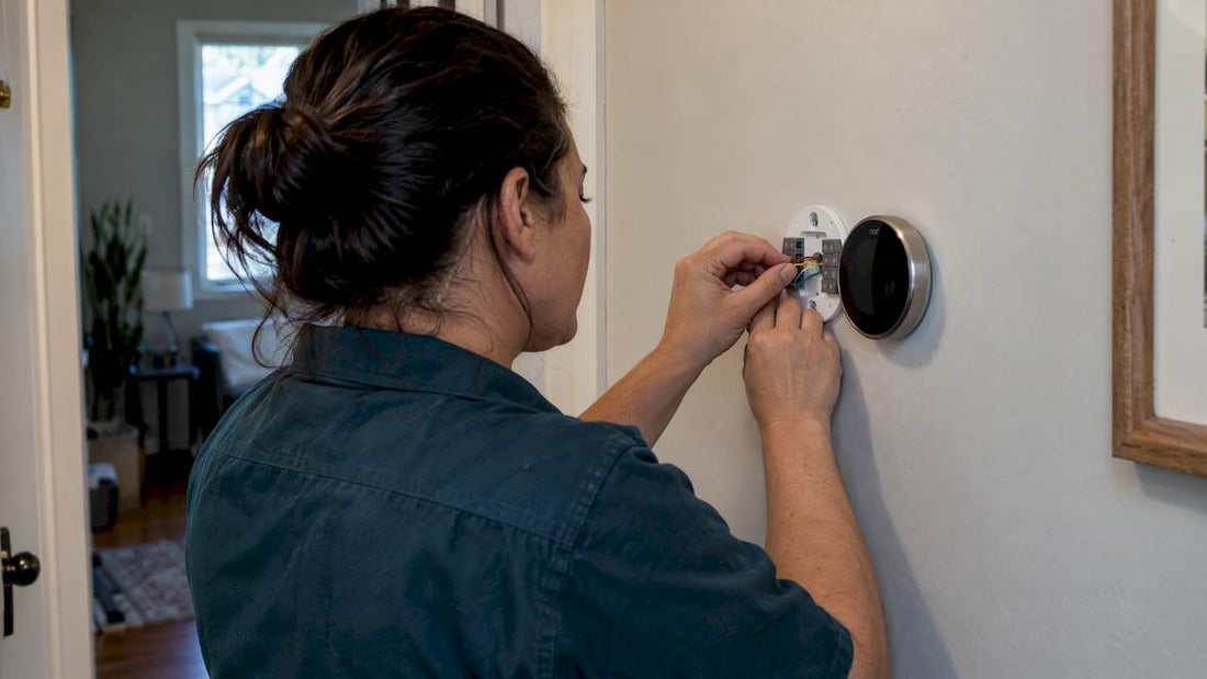 Technician wiring Nest thermostat in US home