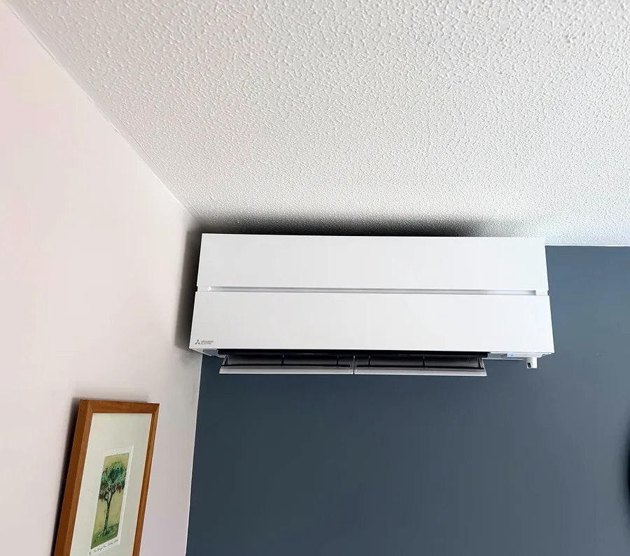 A white Mitsubishi Electric wall unit we fitted above a blue-grey feature wall