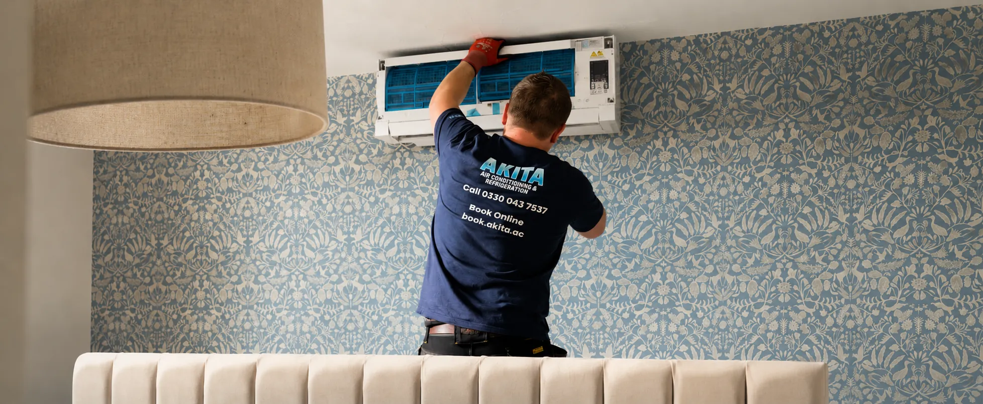 One of our engineers servicing a wall-mounted air conditioning unit in a customer's home